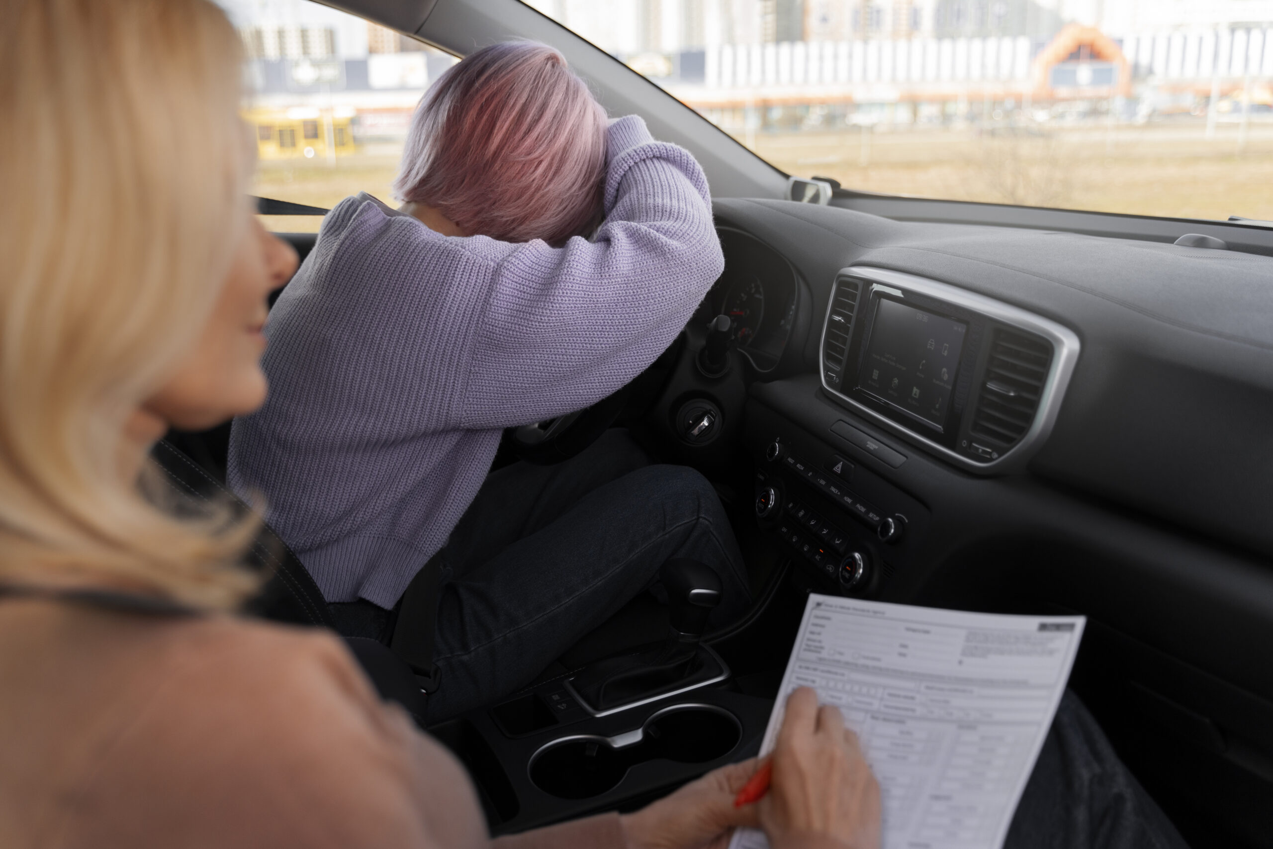 Examinador DGT anotando faltas durante el examen práctico de conducir en ciudad